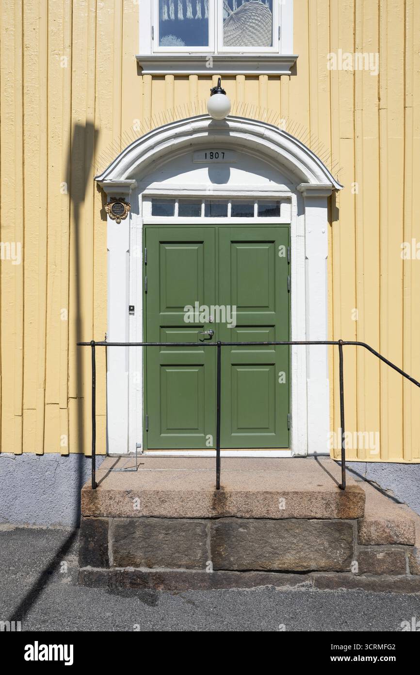 Ingresso di una casa di legno giallo chiaro con porta verde e telaio bianco, Fjaellbacka, Bohuslaen, Svezia occidentale, Svezia Foto Stock