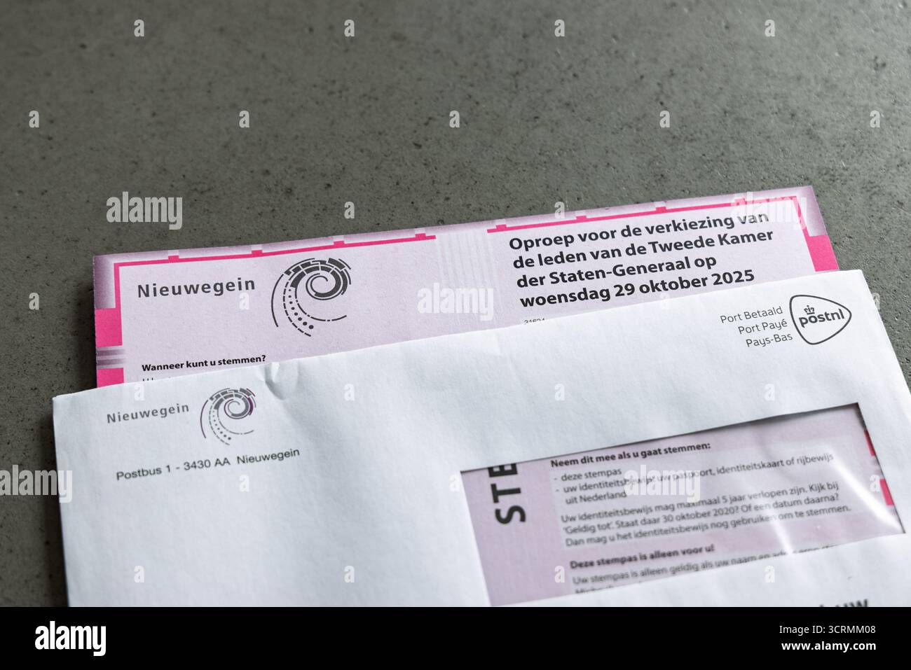 Pass di voto olandese (stempas) e lettera elettorale per le elezioni del parlamento nazionale nei Paesi Bassi, su un sfondo grigio e concreto. Foto Stock