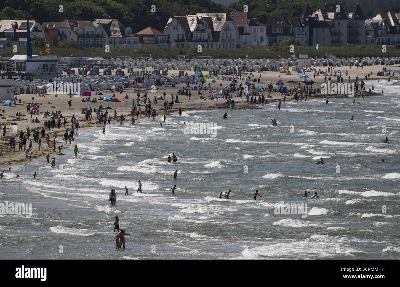Turisti in spiaggia e in mare, onde, sdraio sullo sfondo, Warnemuende, Rostock, Meclemburgo-Vorpommern, Germania Foto Stock