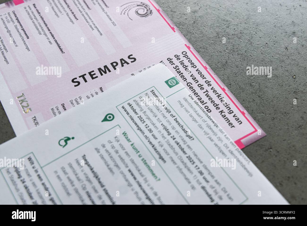 Pass di voto olandese (stempas) e lettera elettorale per le elezioni del parlamento nazionale nei Paesi Bassi, su un sfondo grigio e concreto. Foto Stock