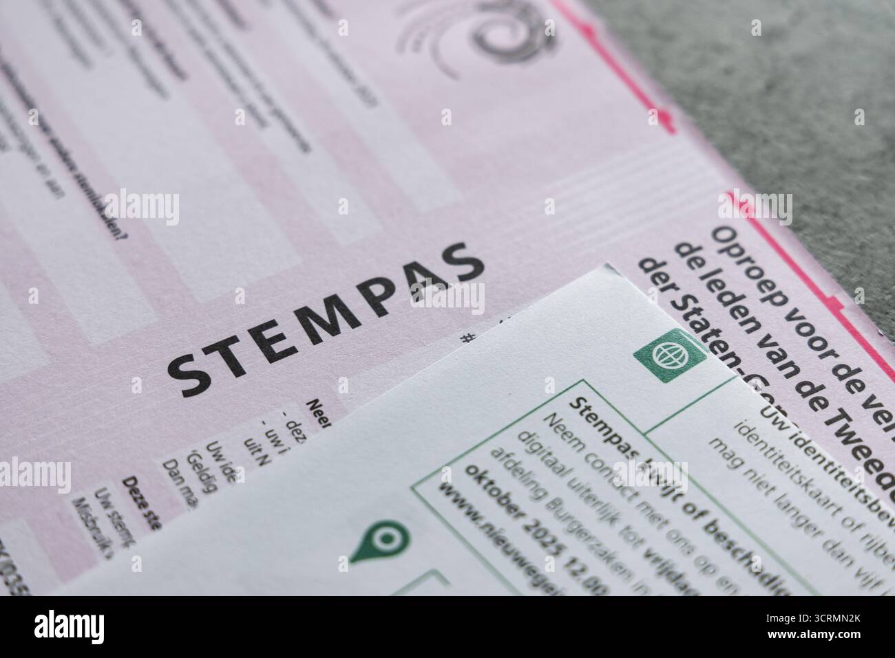 Pass di voto olandese (stempas) e lettera elettorale per le elezioni del parlamento nazionale nei Paesi Bassi, su un sfondo grigio e concreto. Foto Stock