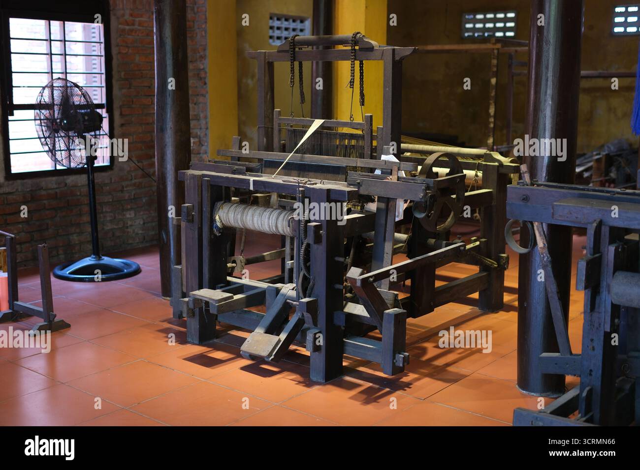 il tradizionale processo di produzione della seta crea con cura il tessuto di seta dall'inizio alla fine. Dalla filatura di finissimi fili di seta alla tessitura su telai in legno, questo artigianato artigianale riflette il patrimonio culturale e l'abilità. Foto Stock