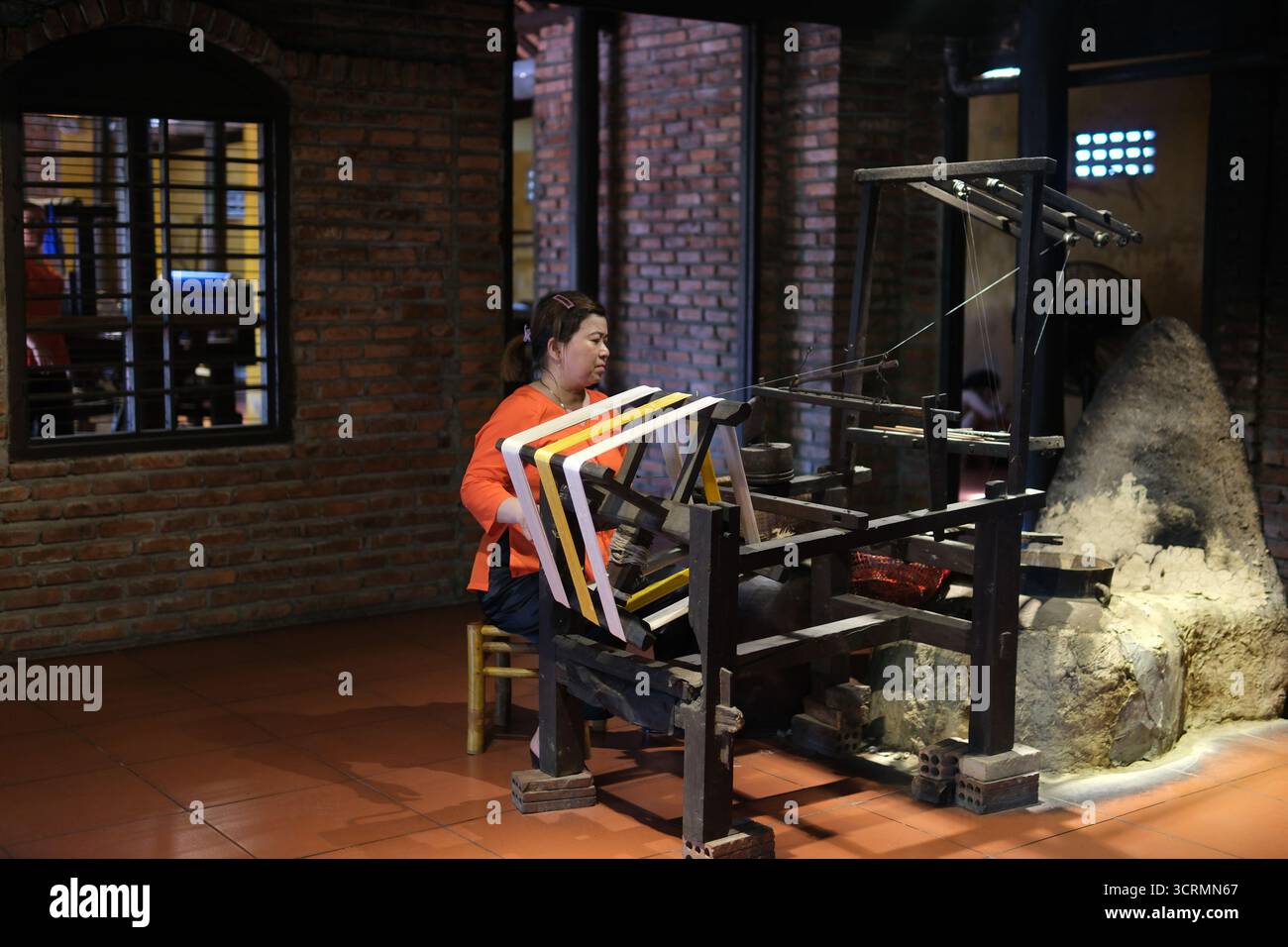 il tradizionale processo di produzione della seta crea con cura il tessuto di seta dall'inizio alla fine. Dalla filatura di finissimi fili di seta alla tessitura su telai in legno, questo artigianato artigianale riflette il patrimonio culturale e l'abilità. Foto Stock