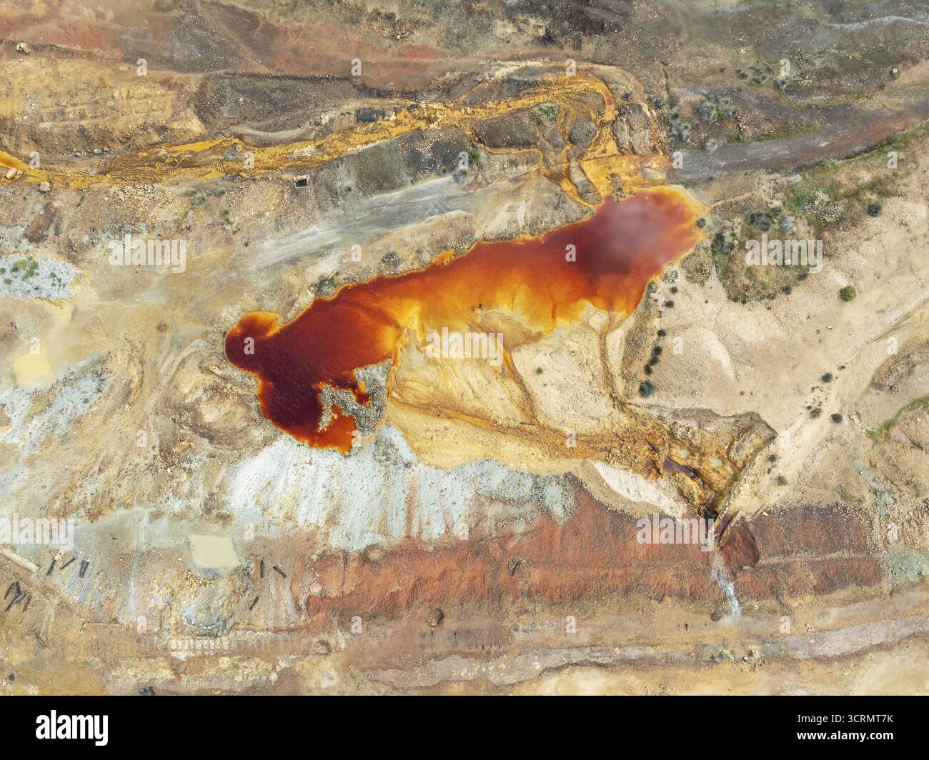 Veduta aerea di un laghetto vibrante color ruggine, un contrasto sorprendente di texture e tonalità nel terreno ricco di minerali di Minas de Ríotinto, Andalusia, Spa Foto Stock