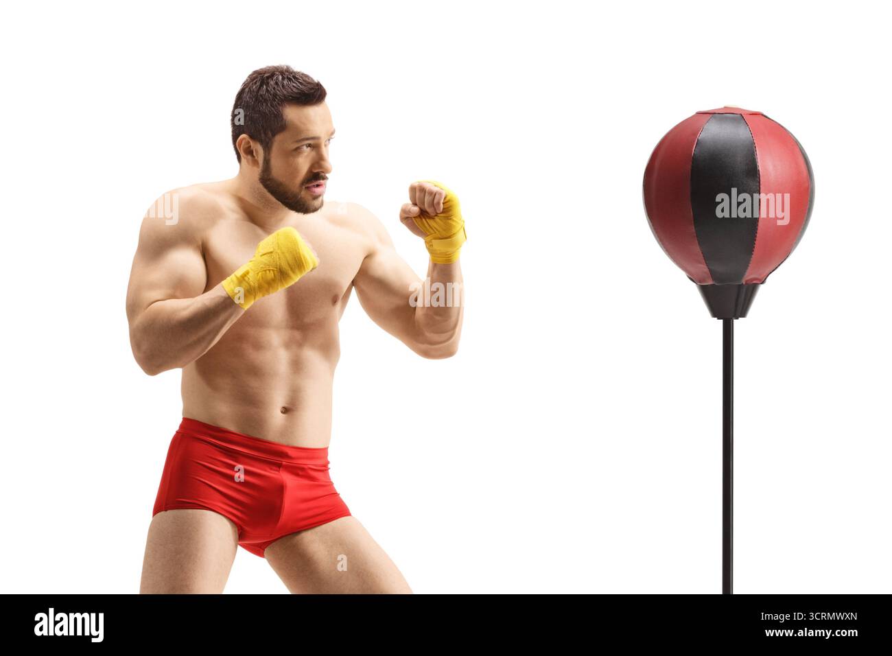 Uomo in pantaloncini rossi che pratica kickboxing con un supporto di pugno isolato su sfondo bianco Foto Stock