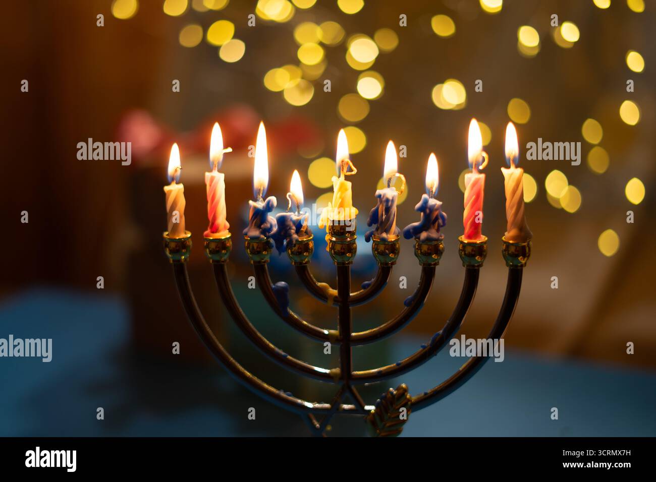 Una menorah con nove candele accese su un morbido e luminoso sfondo bokeh, che evoca calore e pace per celebrare l'Hanukkah. Messa a fuoco selettiva. Foto Stock