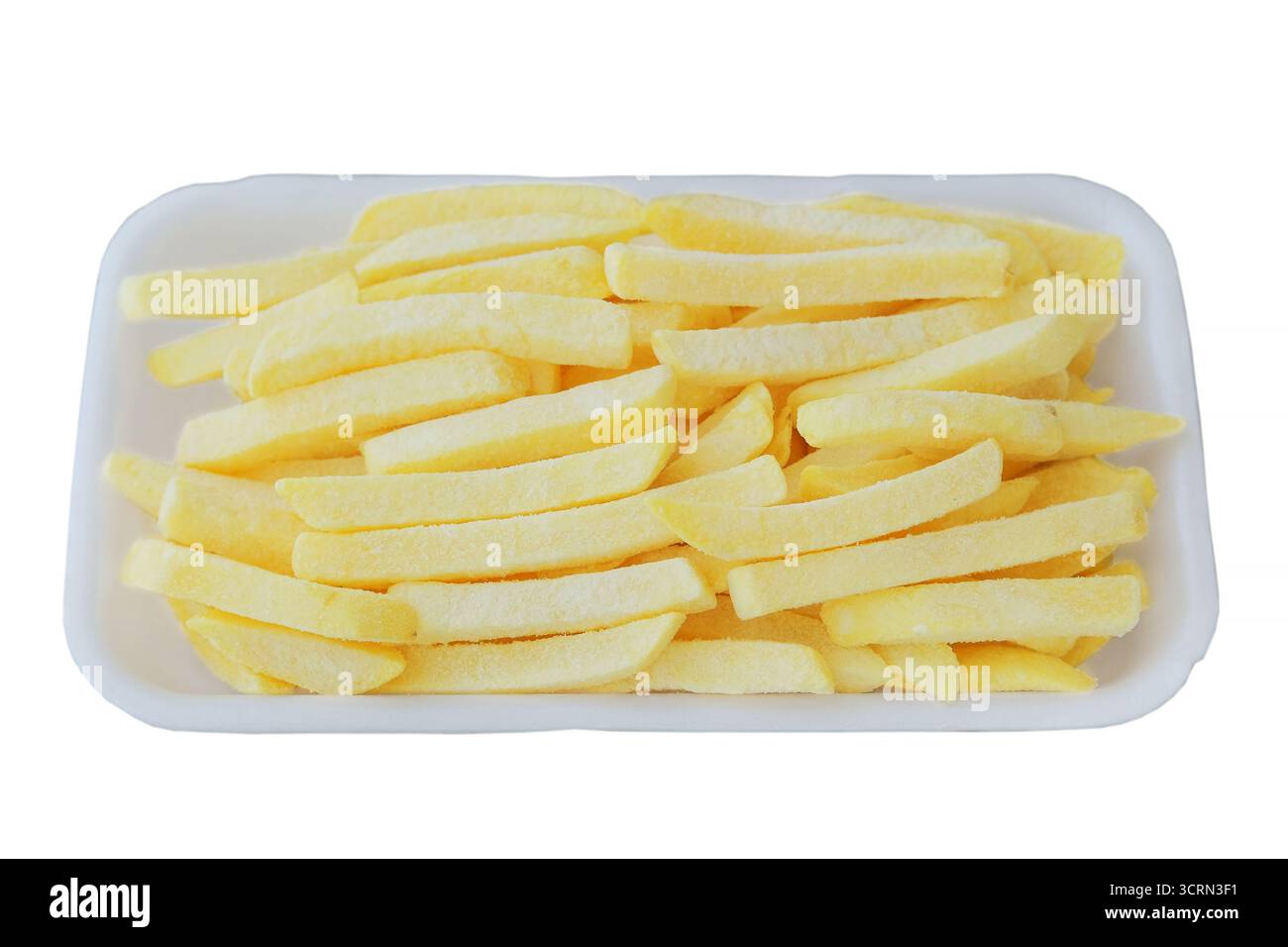 Patatine fritte surgelate su piatto bianco. Patatine gialle in frigorifero. Cucina casalinga. Vista dall'alto. Fast food. Foto Stock