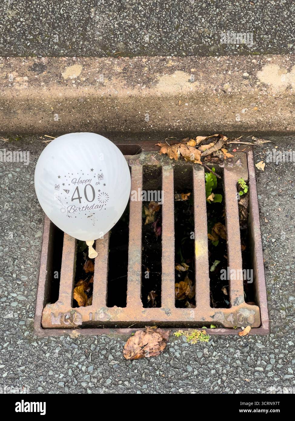 Un palloncino per la festa del 40° compleanno gettato in uno scarico dopo la festa (Regno Unito) Foto Stock