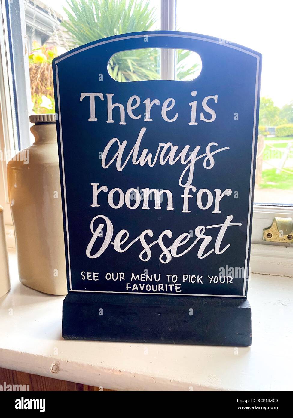 Cartello decorativo in un pub gastronomico che invita i clienti a bere il dessert - Immagine stock catturata con smartphone