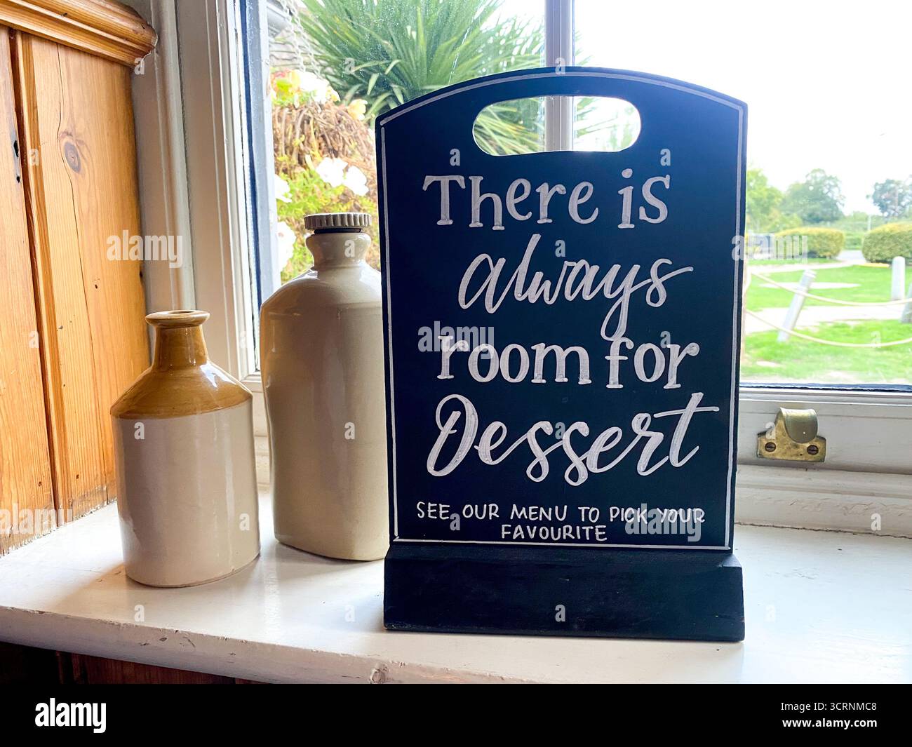 Cartello decorativo in un pub gastronomico che invita i clienti a bere il dessert - Immagine stock catturata con smartphone