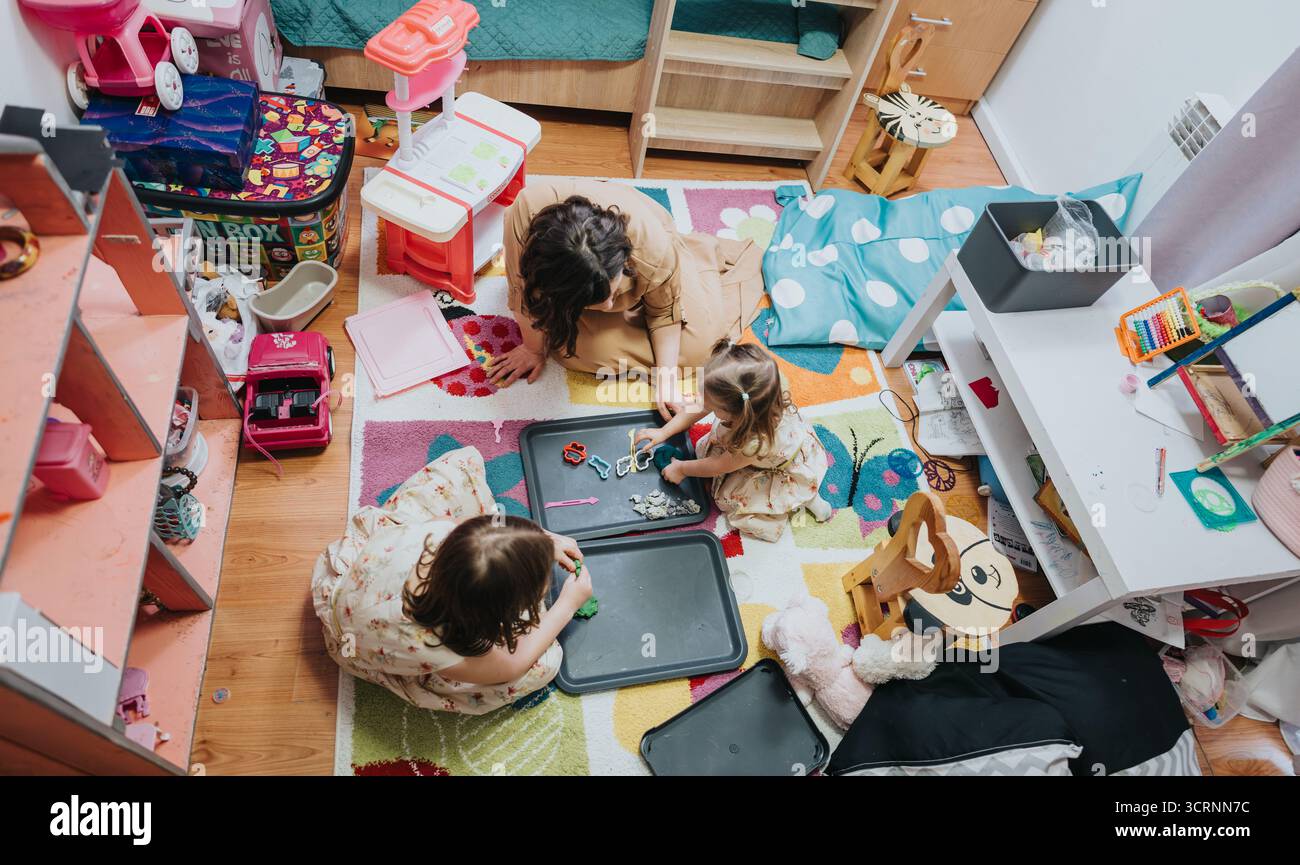 La famiglia si diverte a divertirsi insieme in una colorata sala giochi per bambini Foto Stock