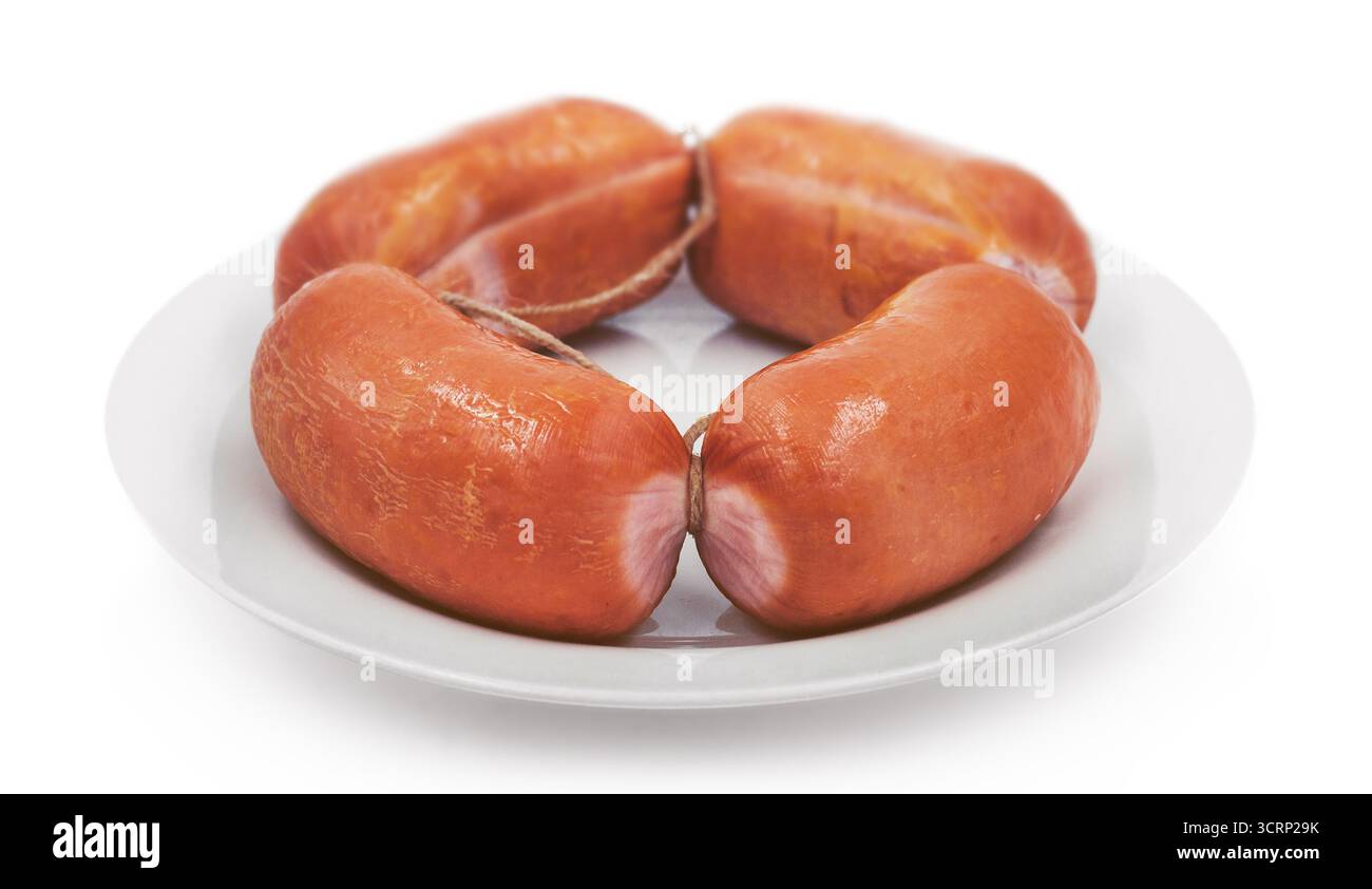 salsicce affumicate di frankfurter su un piatto bianco, isolate Foto Stock