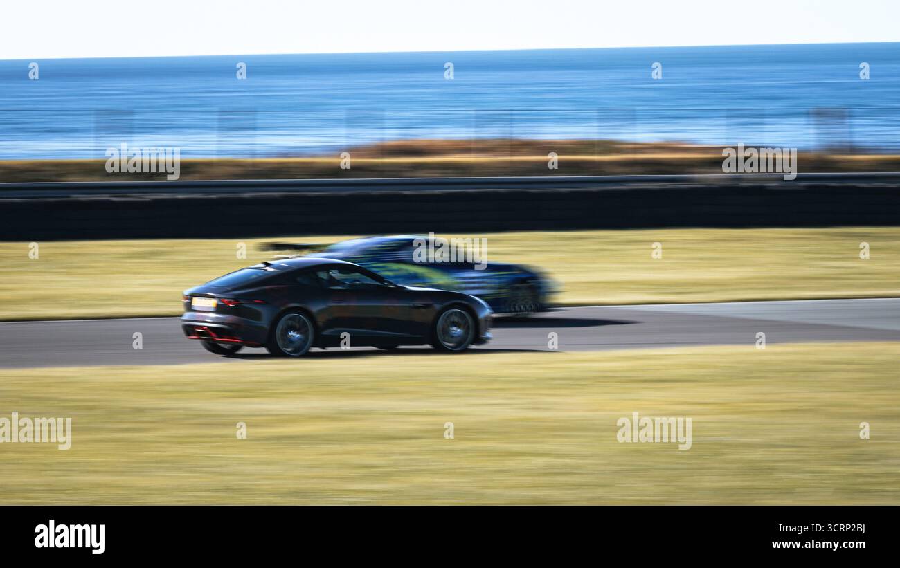 Jaguar F-Type con livrea papavero sul circuito di Anglesey durante la giornata del circuito Mission Motorsport, il sole di settembre, evento motoristico britannico, velocità e stile Foto Stock
