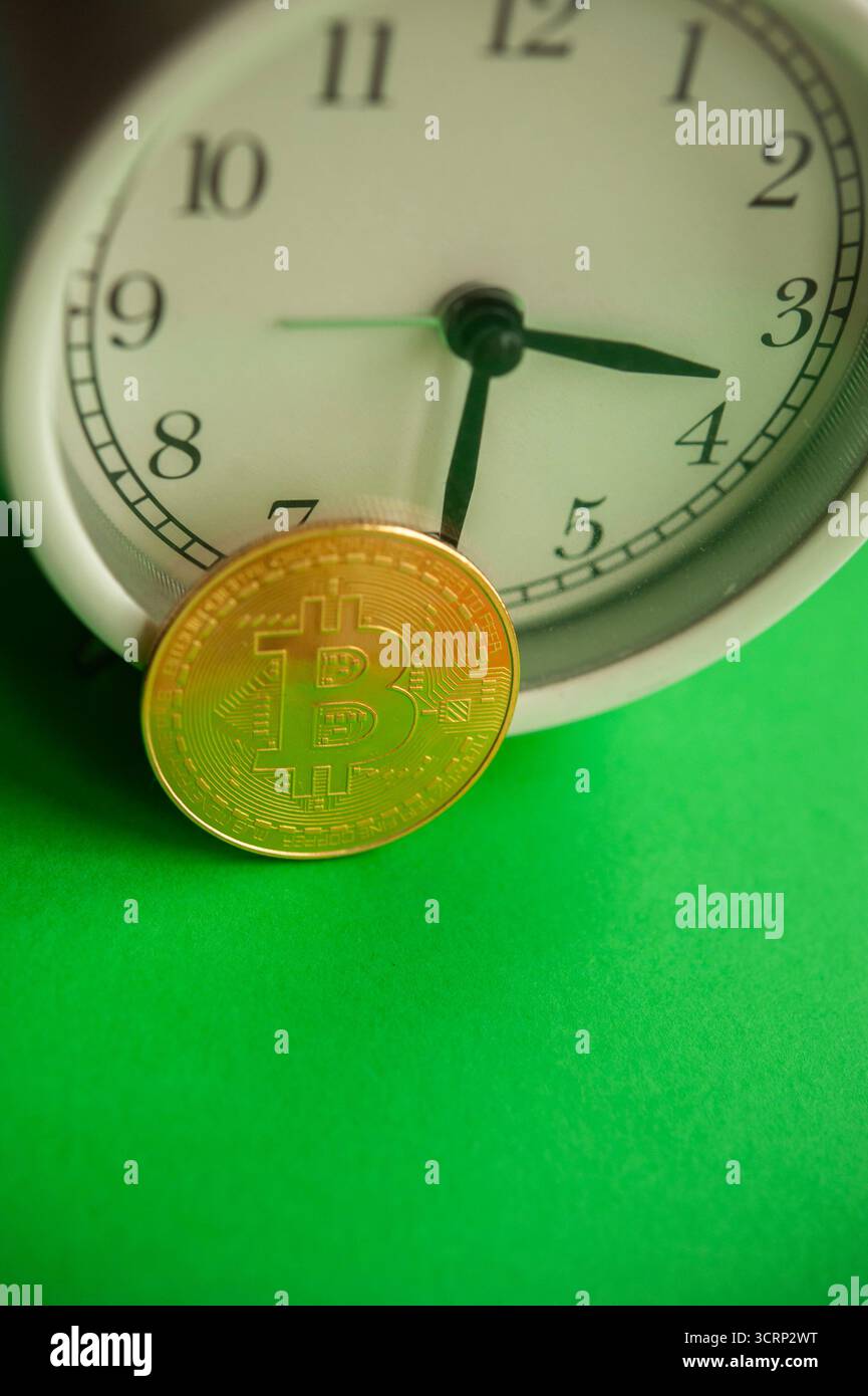 Moneta Bitcoin d'oro appoggiata su un orologio, concetto di tempistica delle criptovalute, investimenti e cicli di mercato Foto Stock