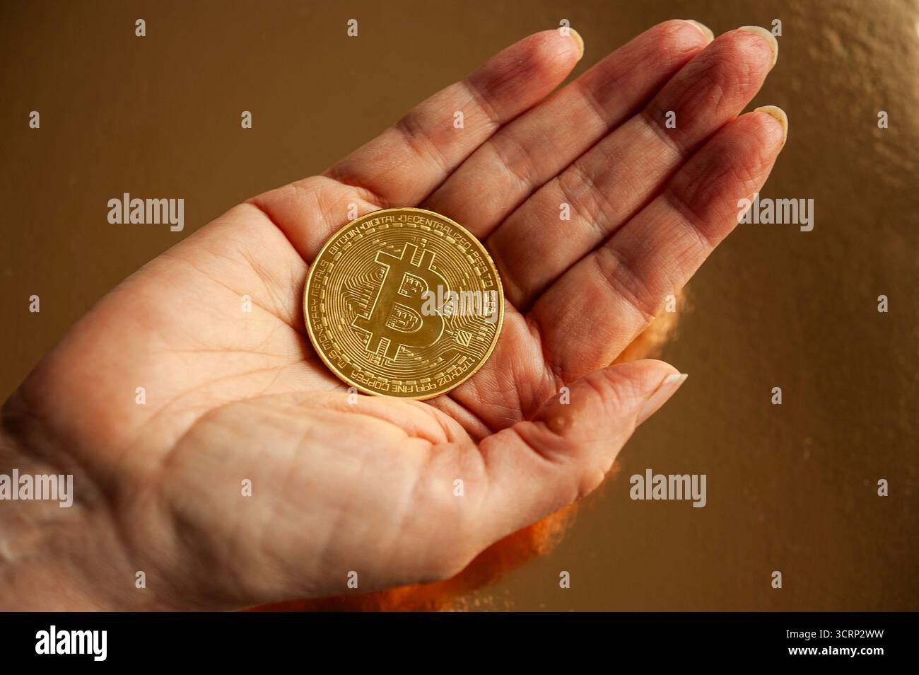 Mano con moneta Bitcoin d'oro, concetto di investimento in criptovaluta, risparmio e finanza personale Foto Stock