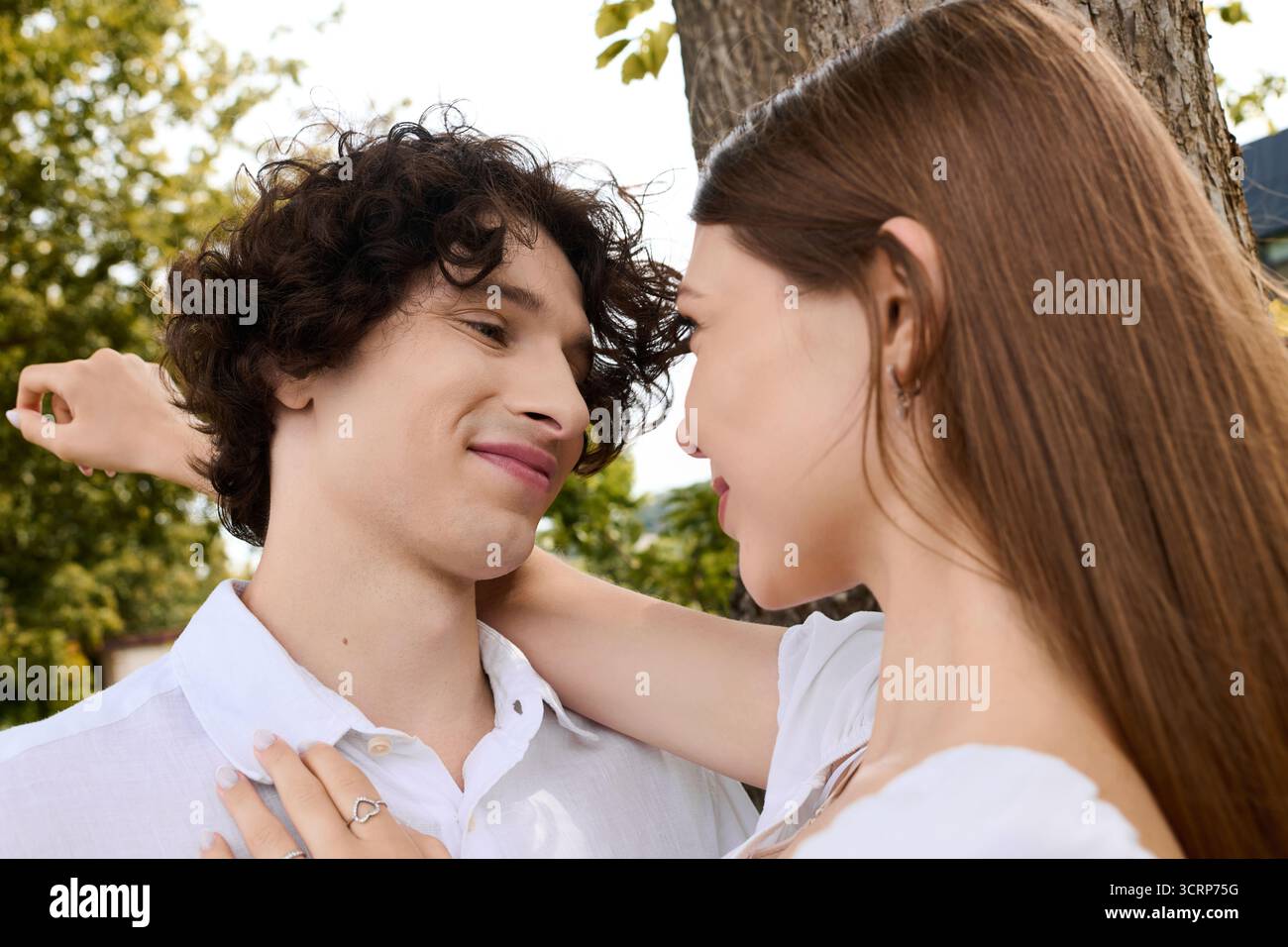 Una coppia felice gode di una giornata di sole insieme, abbracciando l'amore in uno splendido ambiente all'aperto. Foto Stock