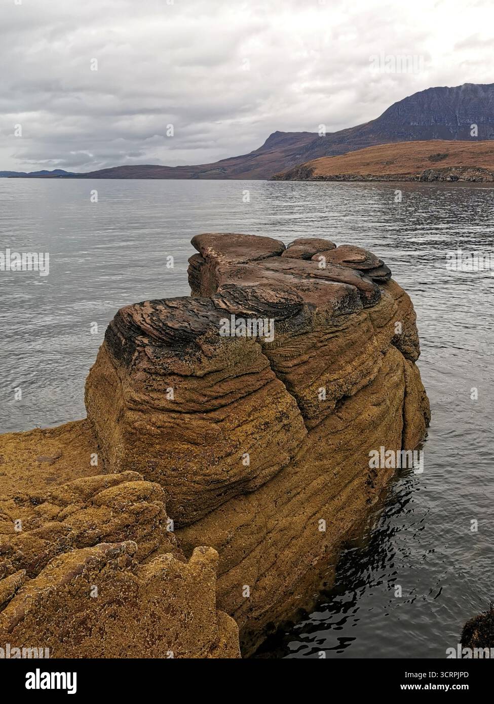 Giant’s Footprint rock vicino al faro di Rhue, Ullapool. Una curiosità naturale scavata nell'arenaria torridoniana e una vista sulla costa settentrionale 500. Foto Stock
