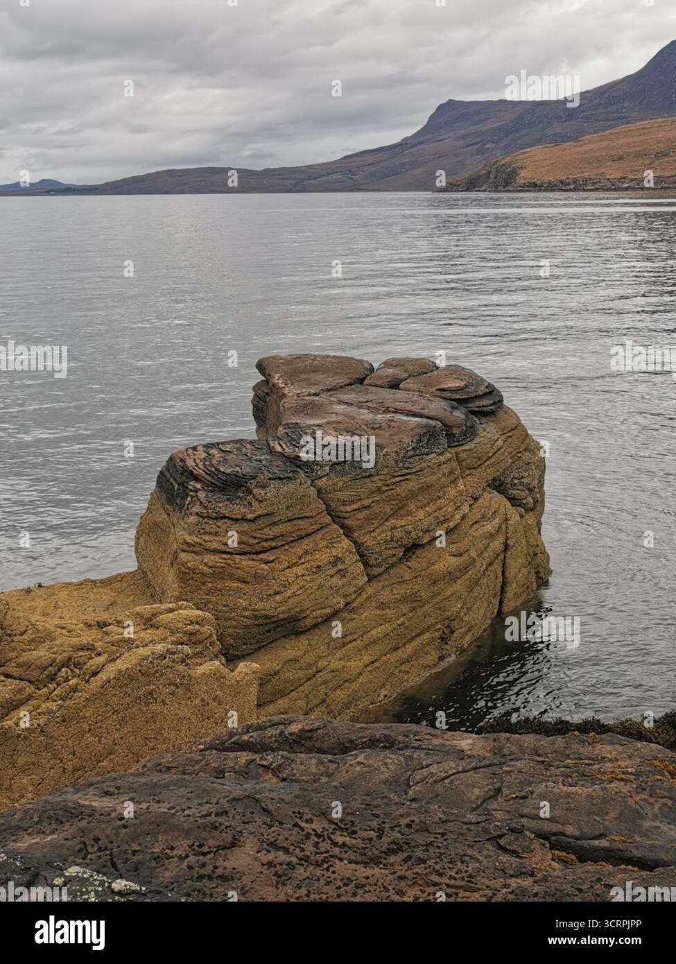 Giant’s Footprint rock vicino al faro di Rhue, Ullapool. Una curiosità naturale scavata nell'arenaria torridoniana e una vista sulla costa settentrionale 500. Foto Stock