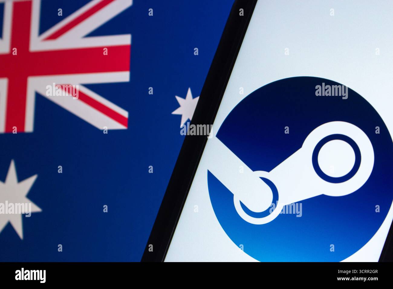Steam, una delle principali piattaforme di gioco per PC, logo visualizzato su uno schermo con una bandiera australiana, che simboleggia le normative sui contenuti e le restrizioni di età in Australia. Foto Stock