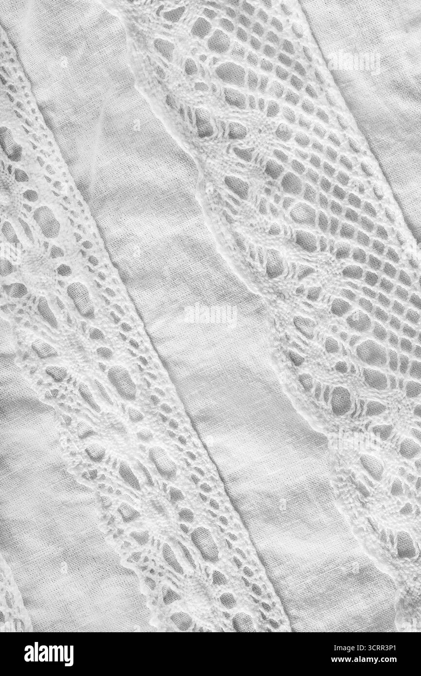 Dettagli in pizzo bianco a crochet su un primo piano in lino bianco come sfondo Foto Stock
