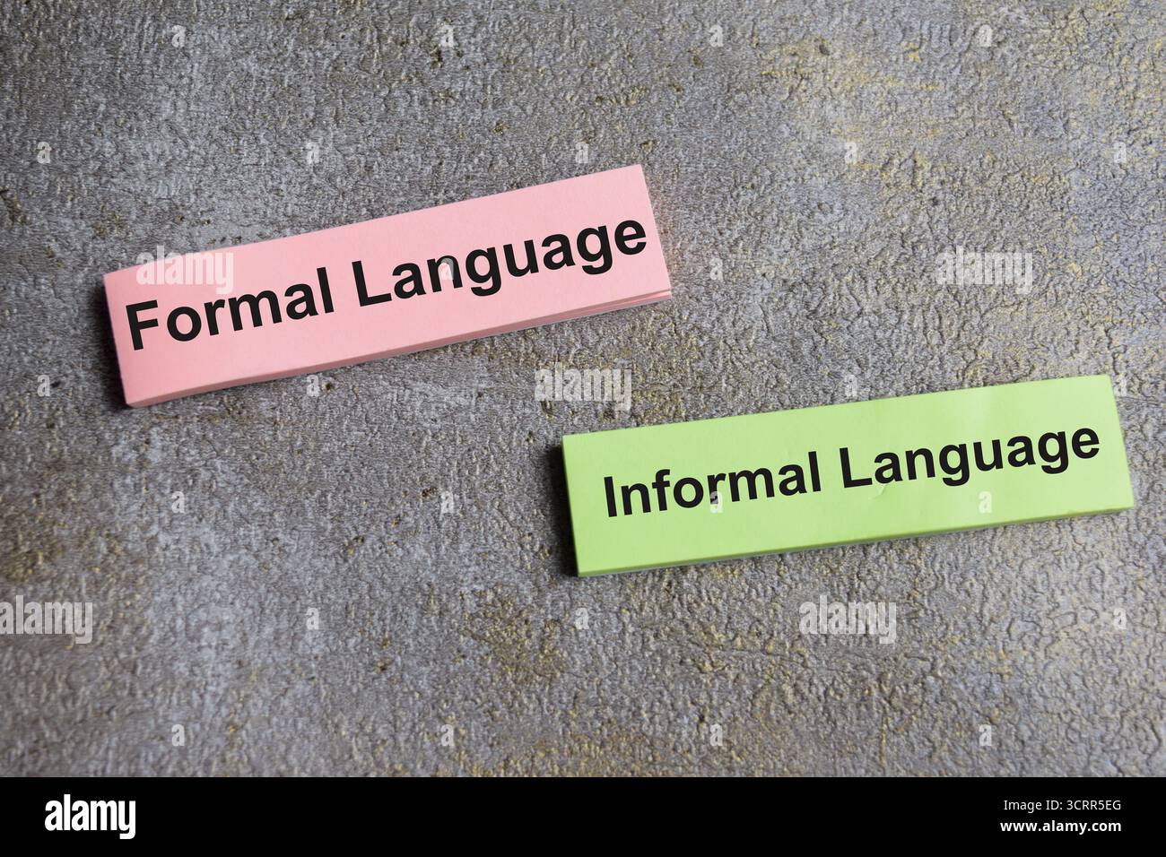 Concetto di linguaggio formale o informale scrivere su appunti isolati su un tavolo di legno. Foto Stock