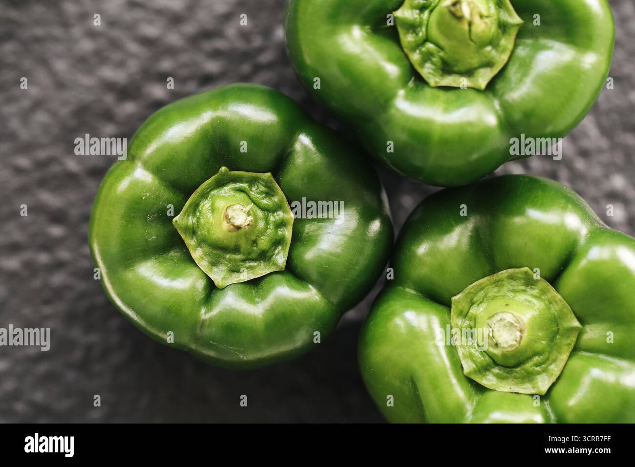 Peperoni verdi freschi primo piano su sfondo scuro. Verdure crude al pepe dolce. Ingredienti di cottura sani e concetto di cibo biologico. Foto Stock