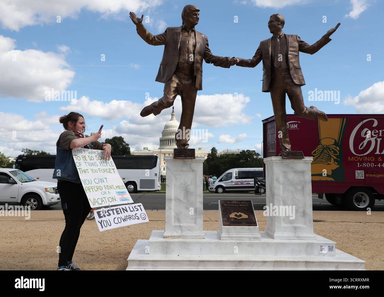 Chiusura del governo a Washington, District of Columbia, USA, Washington DC, Virginia. - 2 ottobre 2025 un attivista protesta accanto a una statua raffigurante il presidente degli Stati Uniti Donald Trump e Jeffrey Epstein che si tengono per mano vicino al Campidoglio degli Stati Uniti il 2 ottobre 2025 a Washington DC. Una statua intitolata Best Friends Forever dal collettivo anonimo d'arte ÒThe Secret HandshakeÓ è stata installata vicino al Campidoglio degli Stati Uniti il 23 settembre e rimossa dal National Park Service il giorno seguente. La scultura è ora misteriosamente riapparsa il 2 ottobre. WASHINGTON DC STATI UNITI d'America Copyright: XGentxShkullakux Foto Stock
