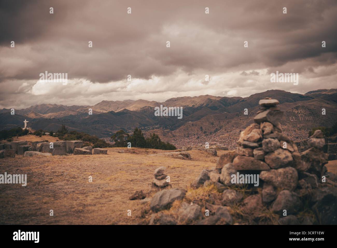 Vista di Cusco e delle circostanti montagne delle Ande dal punto di osservazione Cristo Blanco vicino a Sacsayhuamán, con i cairn di pietra in primo piano. Foto Stock
