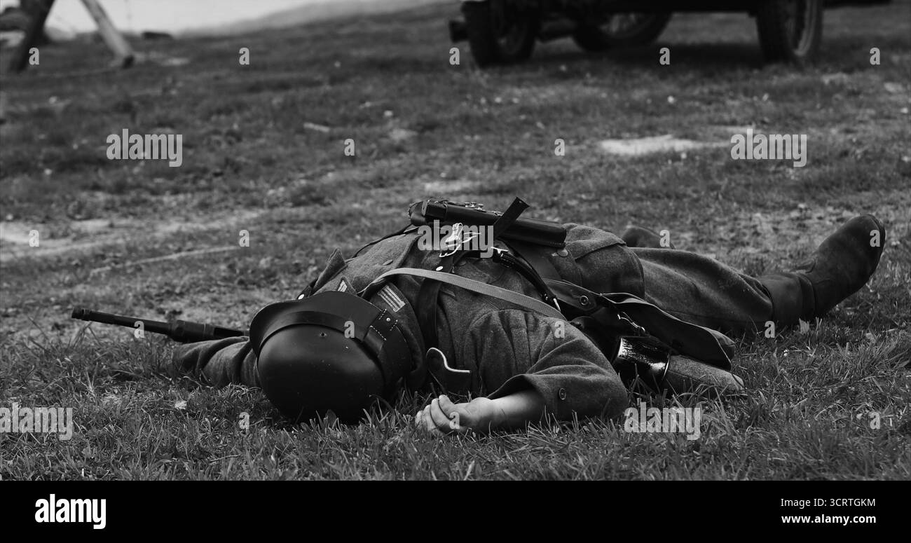 Rievocazione storica del bianco e nero . Re-Enactor vestito da soldato tedesco della Wehrmacht giace ucciso nella ricostruzione delle battaglie della seconda guerra mondiale. Tedesco Foto Stock