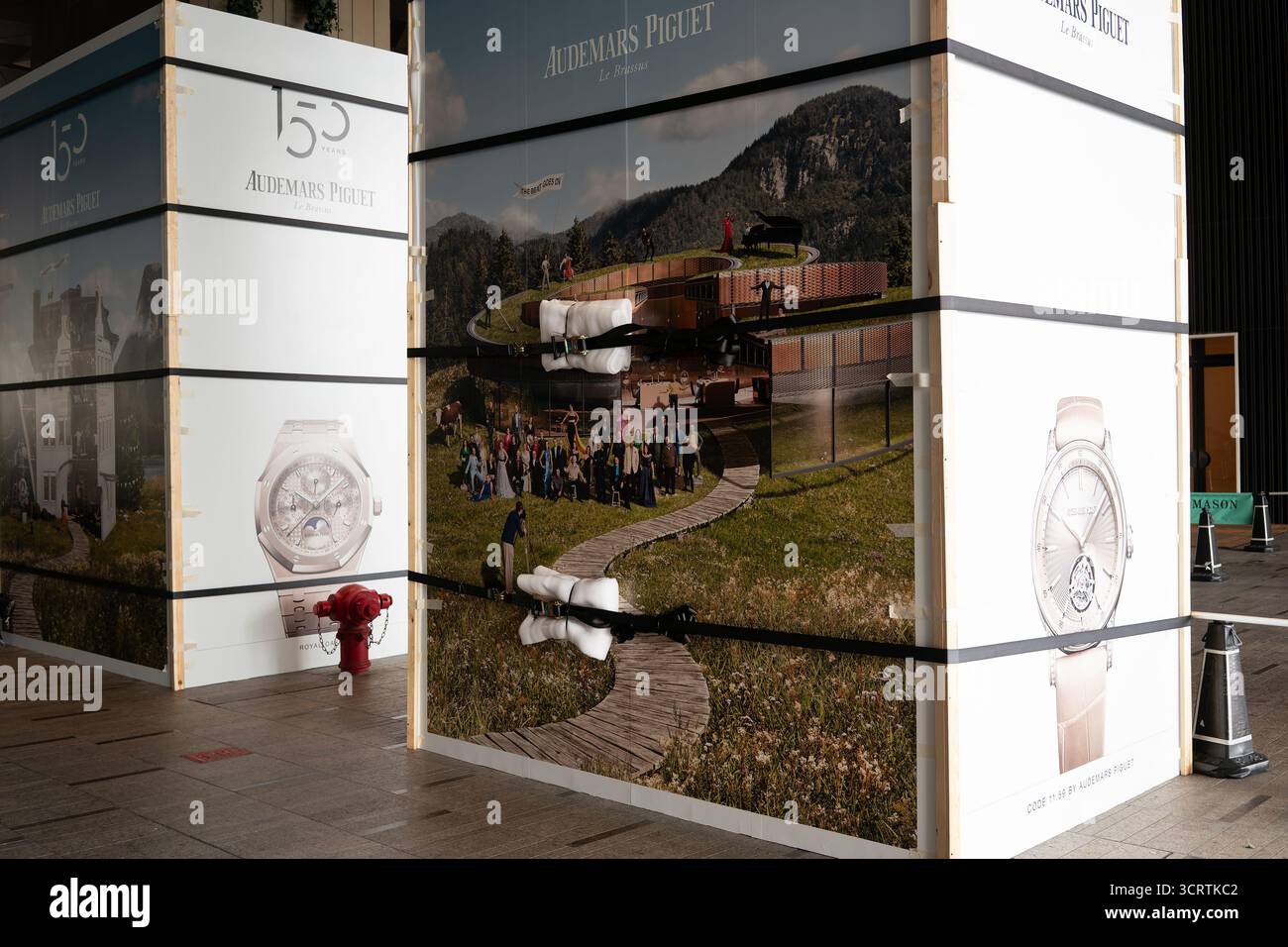 Hong Kong, Cina - 23 settembre 2025: Un cartellone pubblicitario per orologi Audemars Piguet è fissato con cinghie dentate imbottite per evitare danni Foto Stock