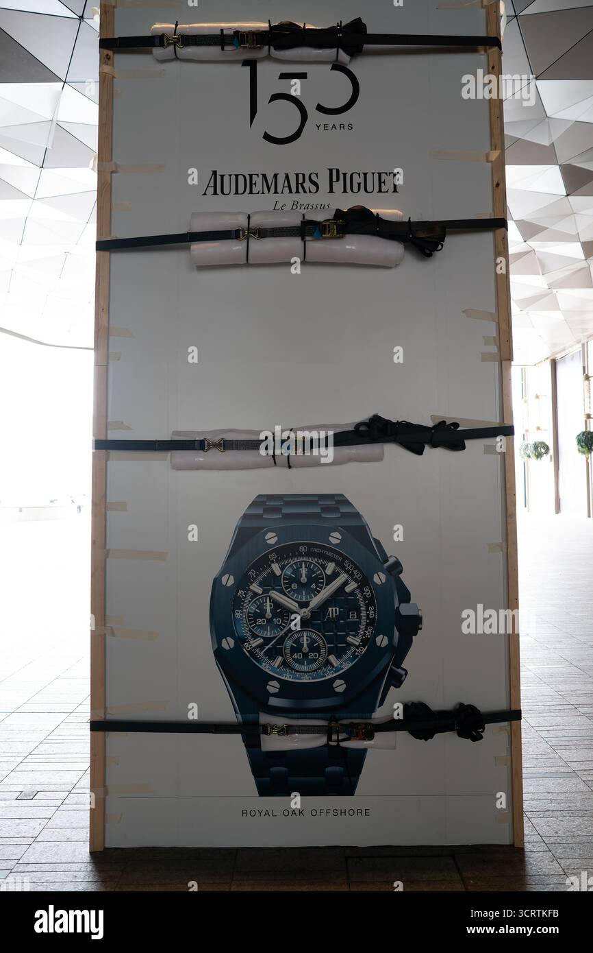 Hong Kong, Cina - 23 settembre 2025: Un cartellone pubblicitario per orologi Audemars Piguet è fissato con cinghie dentate imbottite per evitare danni Foto Stock