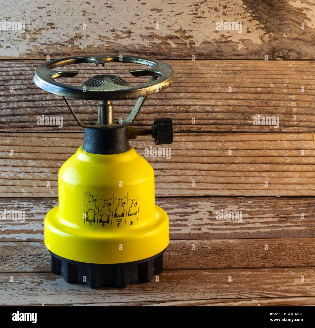 bruciatore portatile giallo su sfondo in legno Foto Stock