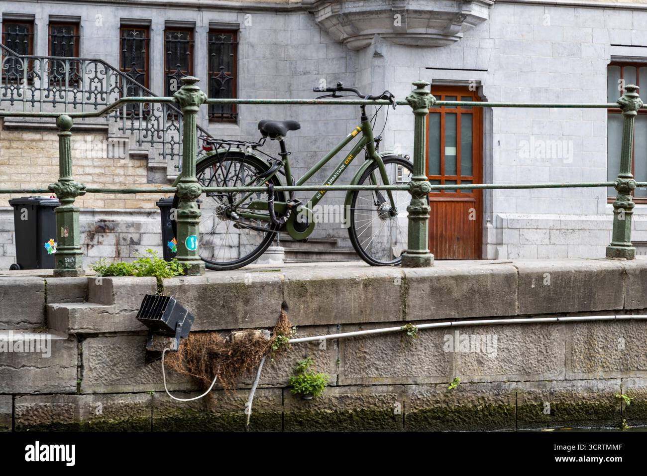 Una bicicletta parcheggiata contro le ringhiere dai gradini del fiume, Gand, Belgio. Foto Stock