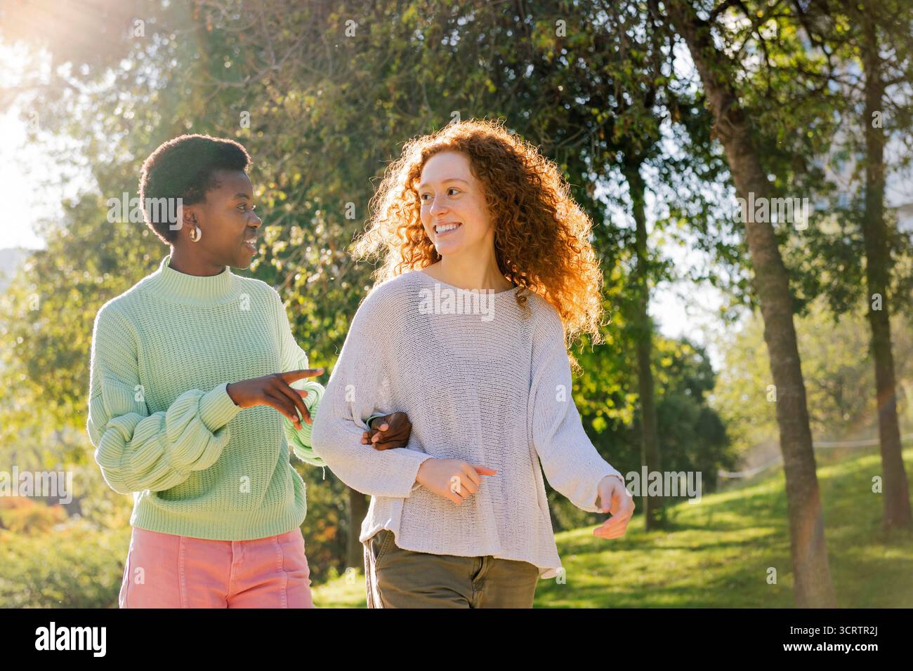 due giovani donne sorridono e parlano durante una passeggiata Foto Stock