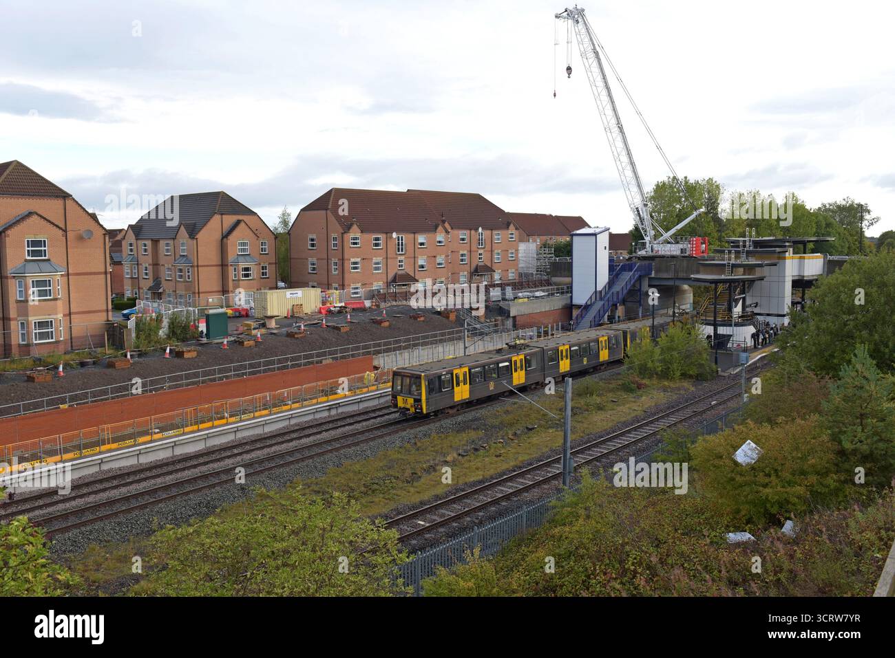 Il servizio Tyne & Wear Metro parte da Northumberland Park, mentre i lavori di costruzione della nuova stazione ferroviaria Northern continuano sullo sfondo, settembre 2025 Foto Stock