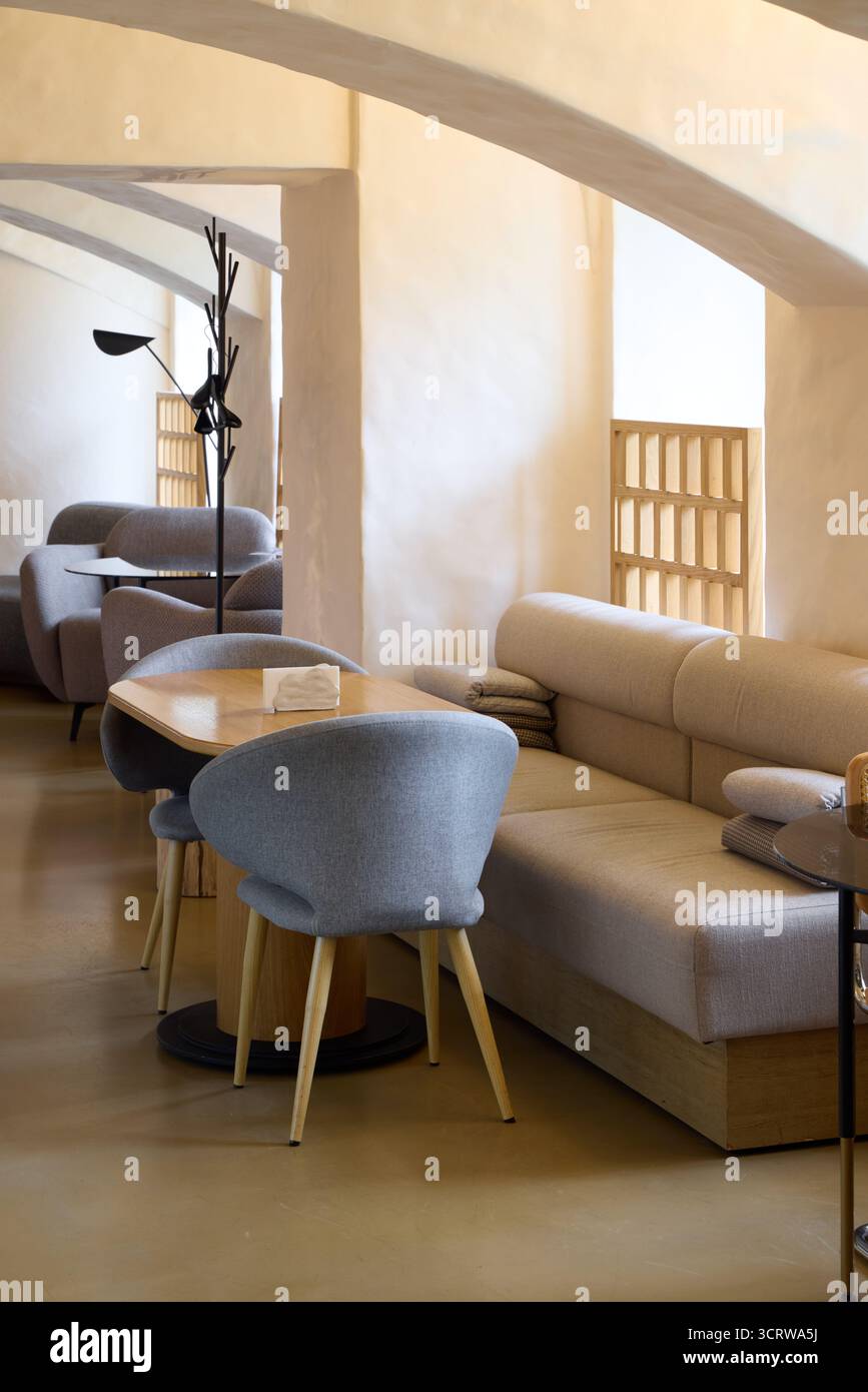 Intimo e moderno Cafe interno con un mix di posti a sedere in toni delicati Foto Stock
