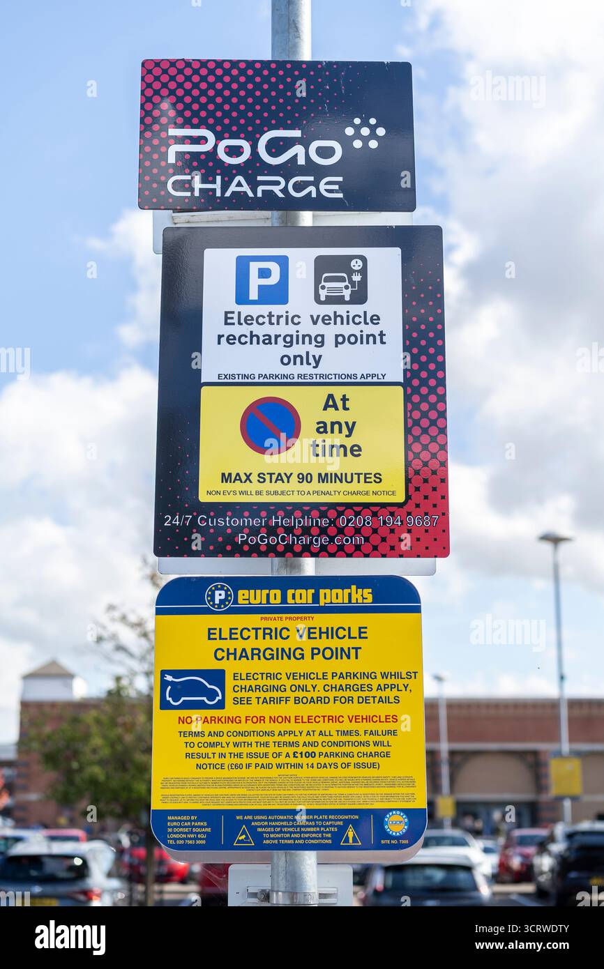 Cartello del punto di ricarica per veicoli elettrici su un parcheggio per negozi al dettaglio. Foto Stock