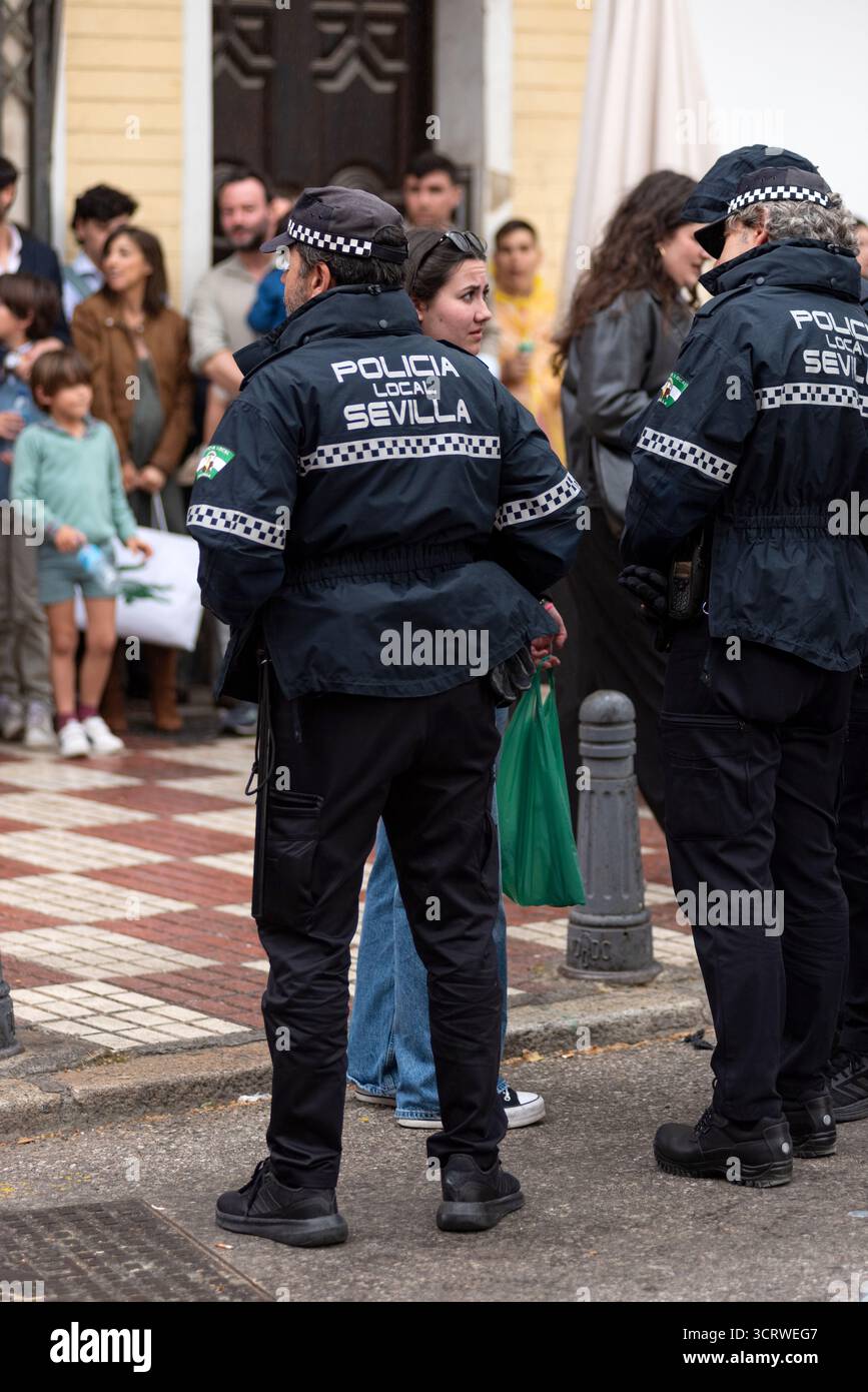 Agenti di polizia municipali in servizio e interagendo con i cittadini durante le celebrazioni della settimana Santa a Siviglia, Spagna. Foto Stock