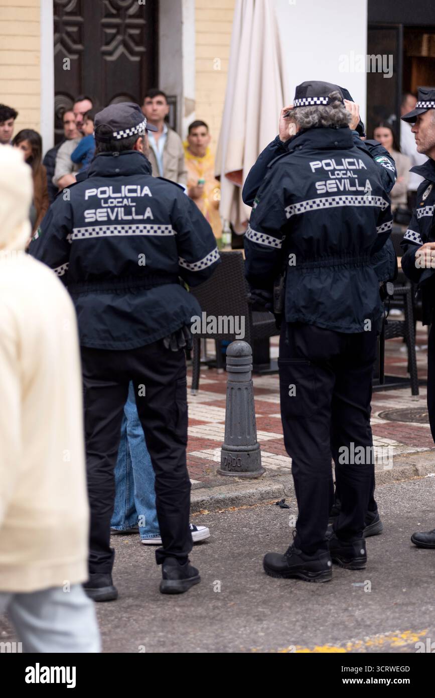 Agenti di polizia municipali in servizio e interagendo con i cittadini durante le celebrazioni della settimana Santa a Siviglia, Spagna. Foto Stock
