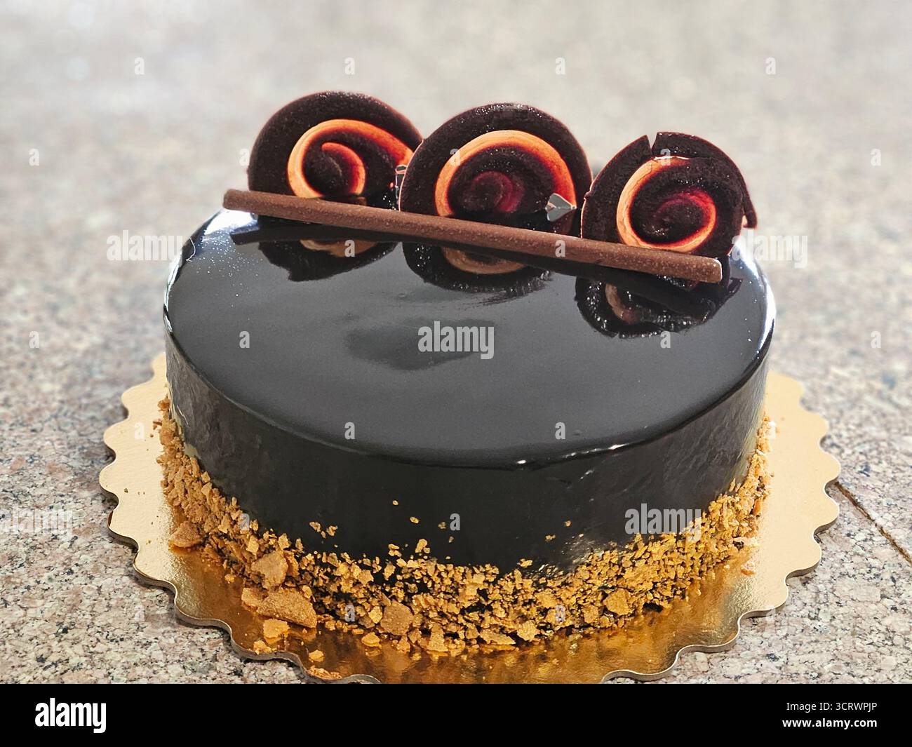 Un gateau di cioccolato luccicante con noci tostate. Foto Stock