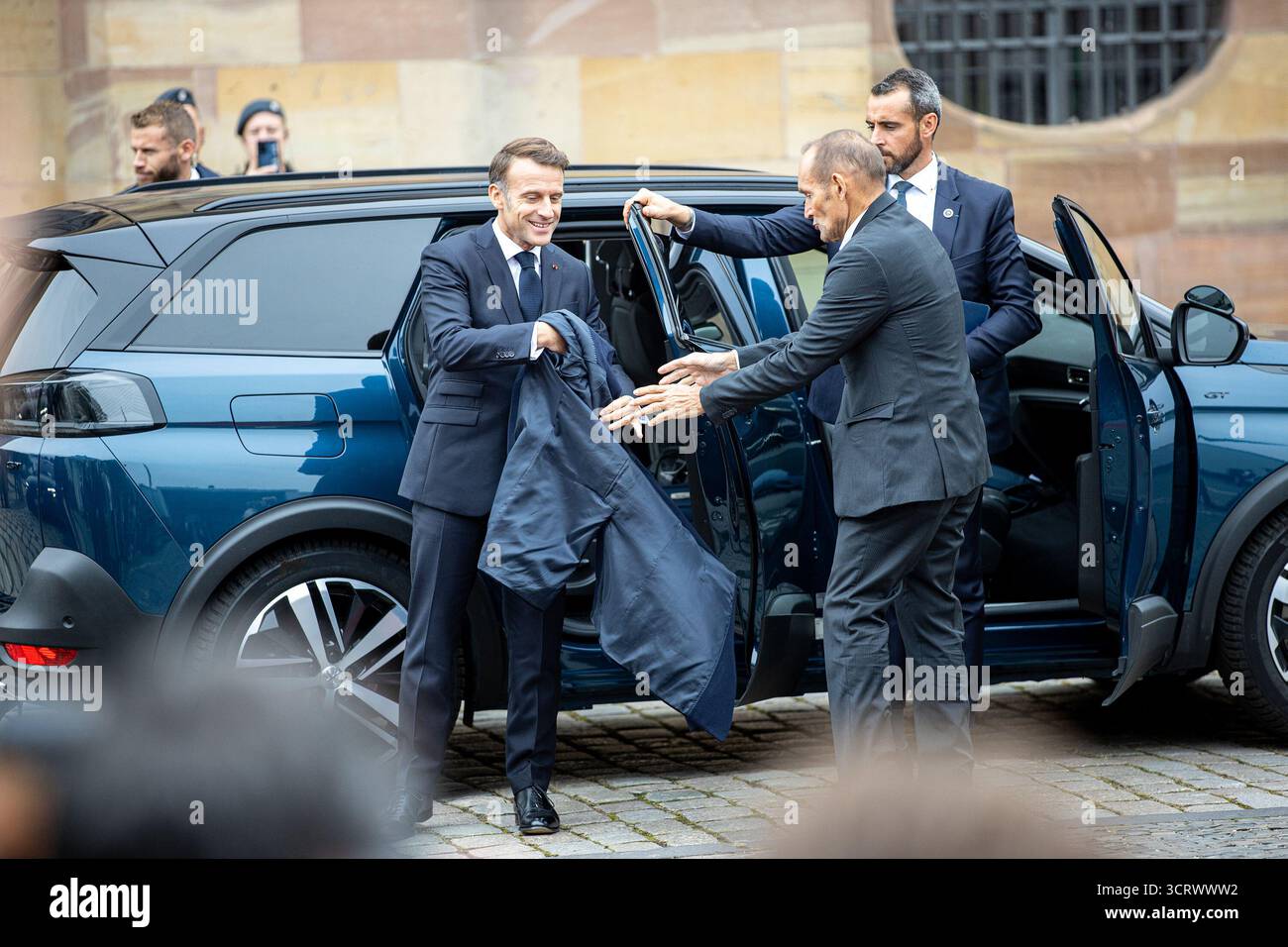 3 ottobre 2025, Saarland, Saarbrücken: Il presidente francese Emmanuel Macron reagisce all'arrivo in auto di fronte alla Cancelleria di Stato della Saarland per le celebrazioni centrali in occasione della giornata dell'unità tedesca. Il 3 ottobre 2025, la Germania celebra il 35° anniversario della riunificazione tedesca. Foto: Pinter Laszlo/dpa Foto Stock