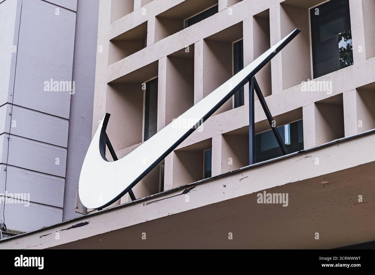 Grande logo Nike bianco montato su un edificio moderno beige Foto Stock