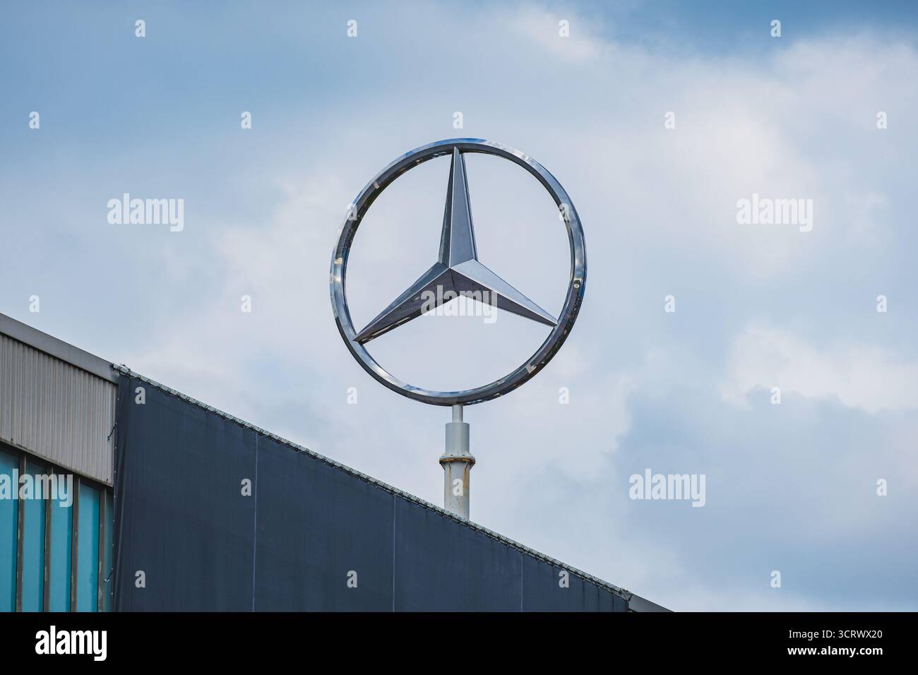 Mercedes-Benz, il famoso logo a tre stelle del marchio tedesco di veicoli commerciali e di lusso sul tetto dello stabilimento del marchio Foto Stock