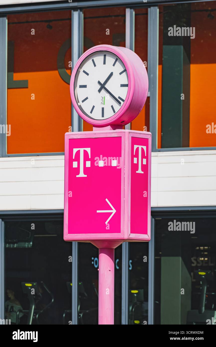 Logo del marchio Deutsche Telekom Telekom Telecommunications sullo stand pubblicitario con l'orologio nella parte superiore Foto Stock