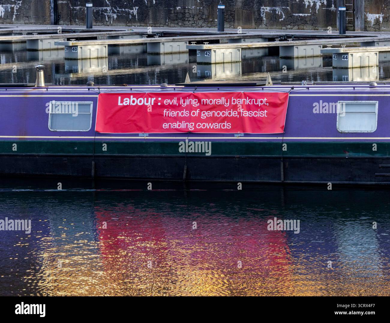 Una barca di stretta al Royal Albert Dock durante la conferenza sul lavoro definì i laburisti "maligni moralmente falliti amici del genocidio fascista che permette codardi”. Foto Stock
