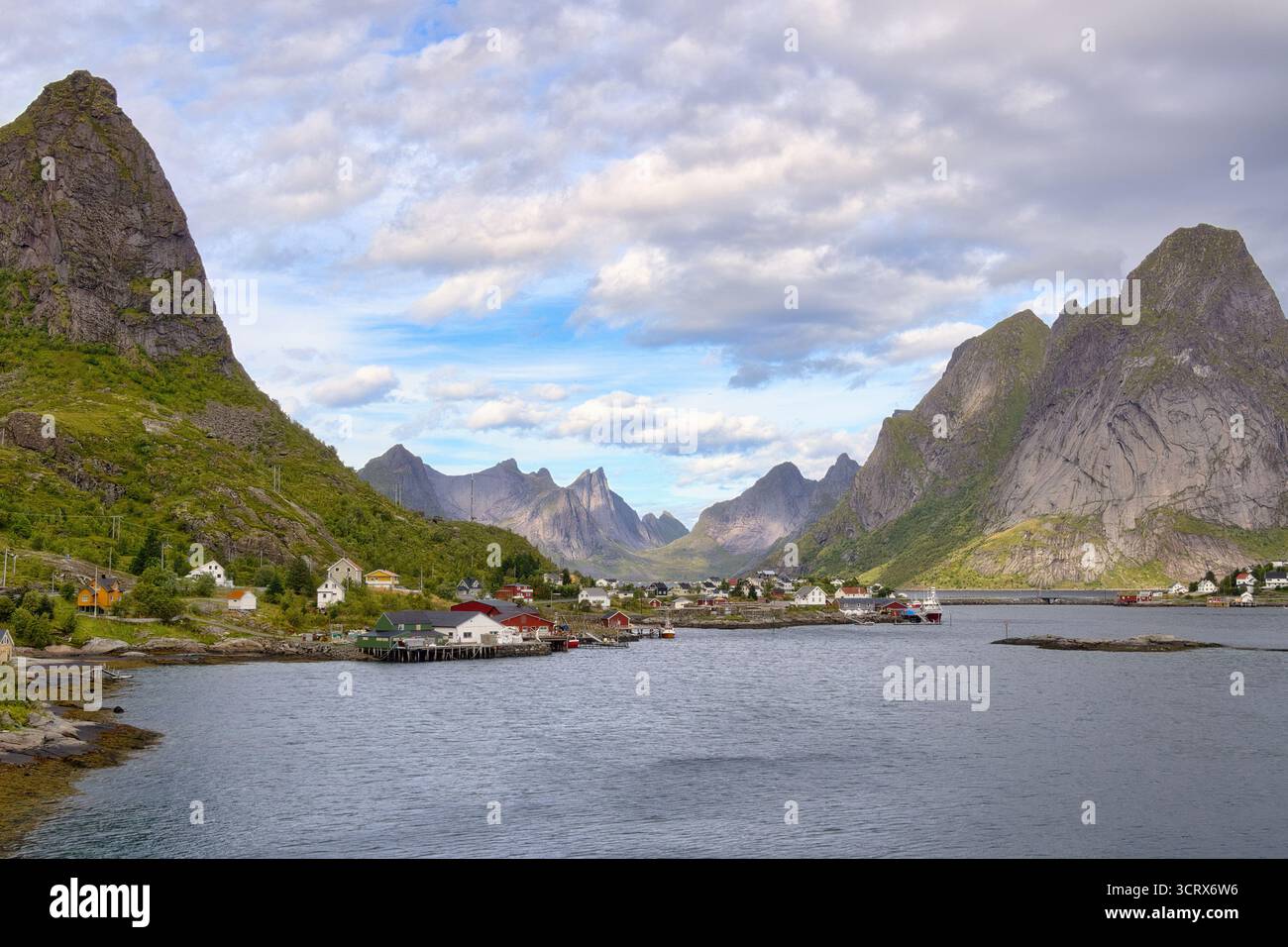 Un paesaggio mozzafiato con torreggianti montagne che nano l'affascinante villaggio di pescatori di Reine sull'arcipelago Lofoten in Norvegia. Foto Stock