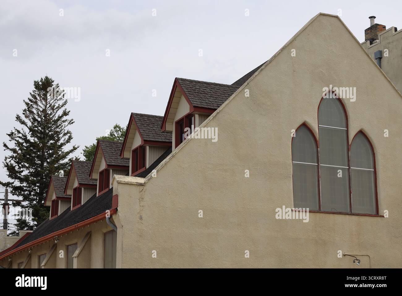 finestre dormer in cima a un edificio religioso di un tempo sotto cieli nuvolosi grigi Foto Stock