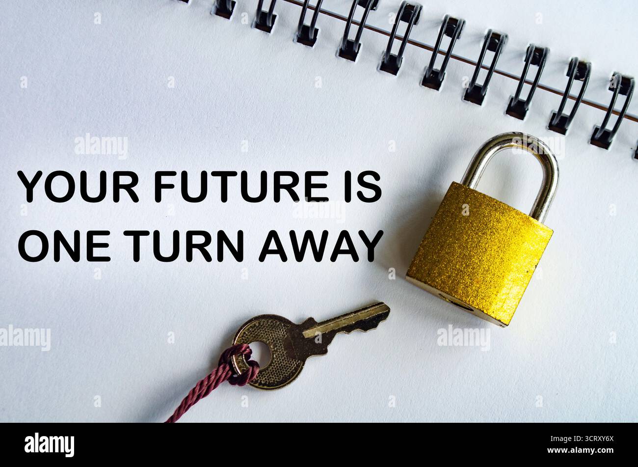 IL TUO FUTURO È UN PASSO INDIETRO, un blocco note motivazionale con lucchetto e chiave che enfatizza l'ottimismo e l'azione Foto Stock