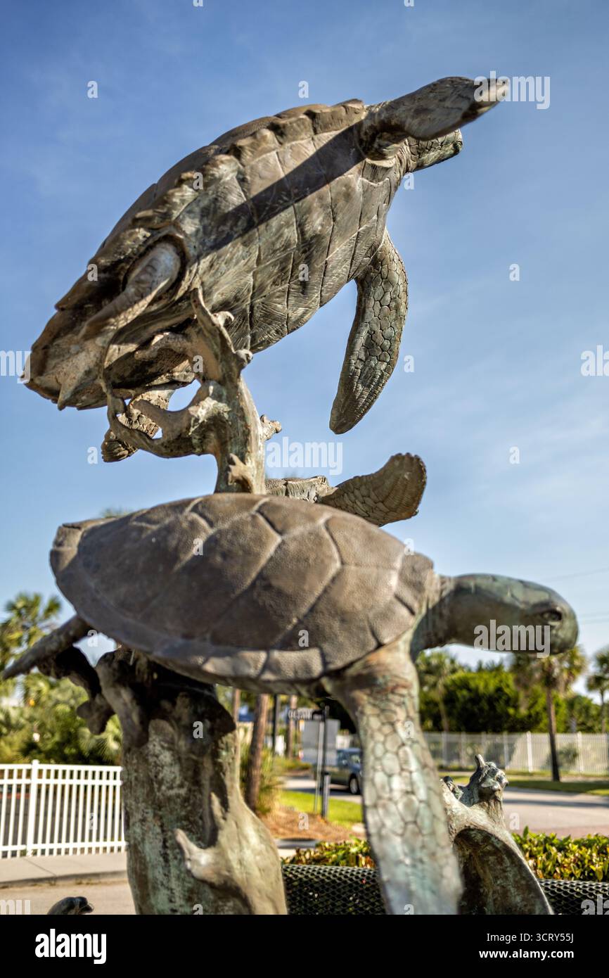 Loggerhead Hatchling Sculpture Ocean Boulevard Isle of Palms South Carolina // ISLE OF PALMS, South Carolina — Una scultura bronzea di boscaglia dell'artista di Charleston Scott Penegar si trova su Ocean Boulevard, parte della Hatchling Hunt della città (2019-2020). Questa è una delle sei sculture, ciascuna abbinata a una targa che spiega una fase della vita della testa di legna. La stazione n. 4, intitolata Hatchlings Swim, raffigura giovani tartarughe che si innalzano sopra forme ondeggianti. L'opera d'arte mette in risalto il pericoloso viaggio che i vivai della testa di cocco intraprendono per raggiungere la corrente del Golfo. Sottolinea anche gli impegni di Isle of Palms Foto Stock
