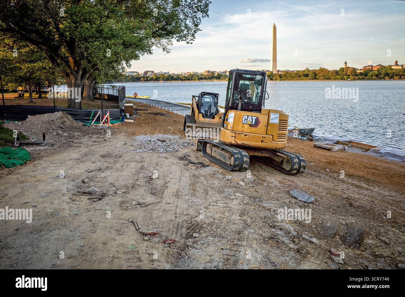 Tidal Basin Seawall Reconstruction Project Washington DC // WASHINGTON DC — Un escavatore CAT e materiali da costruzione sono visibili presso il cantiere del Tidal Basin Seawall Reconstruction Project vicino all'Inlet Bridge il 2 ottobre 2025. Questo progetto critico riguarda il deterioramento delle dighe del bacino delle maree, che subiscono quotidianamente inondazioni dovute al cedimento e all'innalzamento del livello del mare. La ricostruzione mira a ricostruire e innalzare le banchine, proteggendo monumenti iconici come il Jefferson Memorial e il National Mall, incluso il Monumento a Washington visibile. Foto Stock